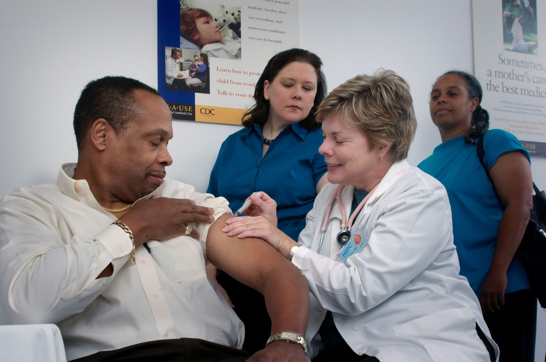 A healthcare professional administers a shot to a patient